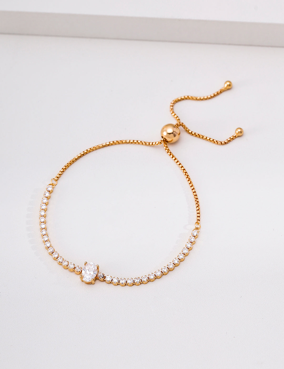 Vintage gold cubic zirconia tennis bracelet with an oval centre stone and adjustable sliding clasp