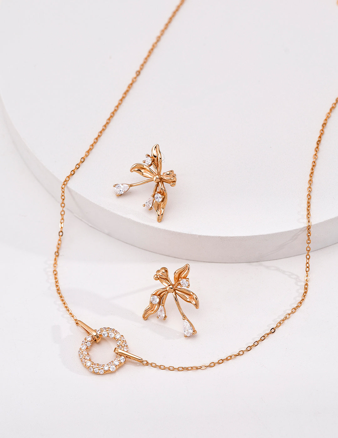 Vintage gold cubic zirconia circle pendant necklace styled beside floral drop earrings