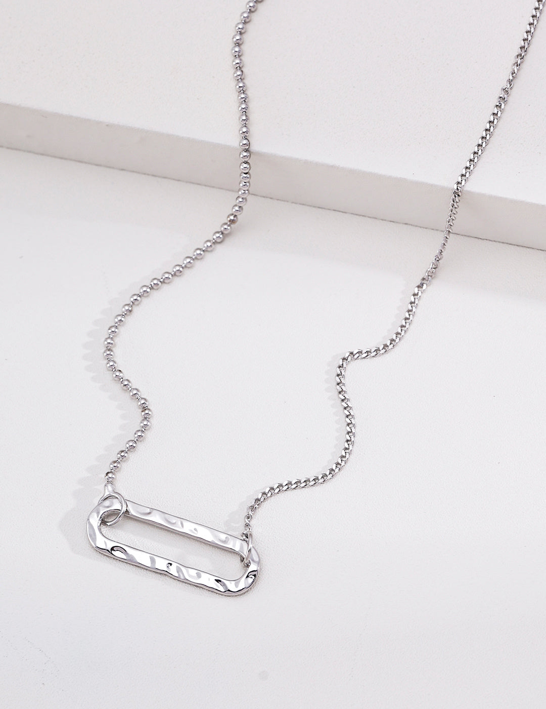 Silver textured rectangle pendant necklace with an asymmetric ball and curb chain
