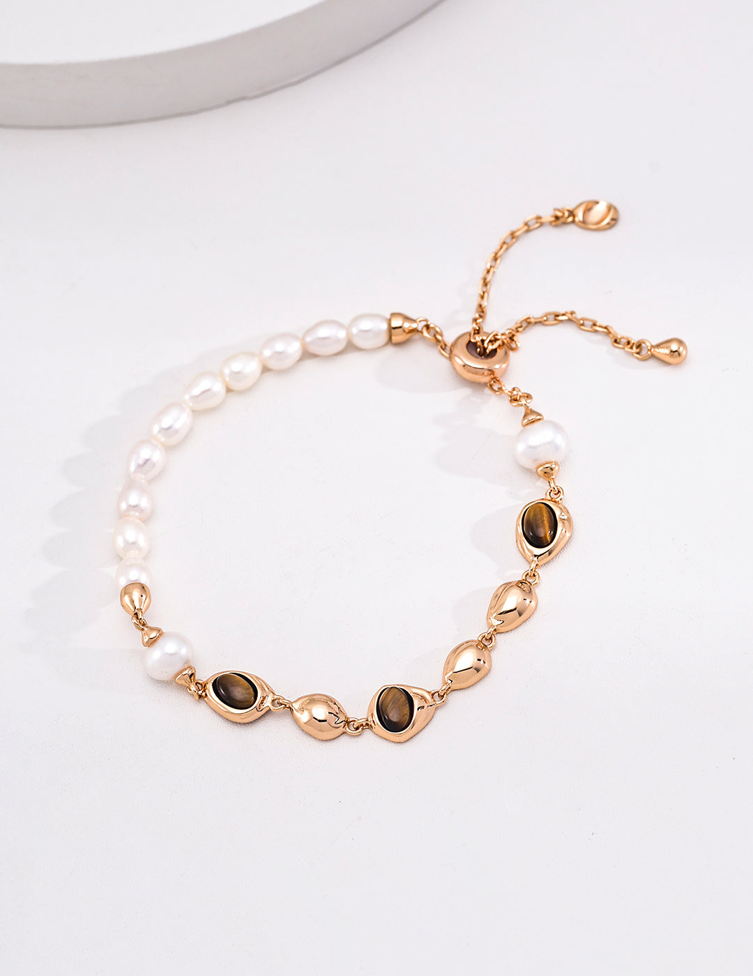 Pearl and brown stone bracelet with polished pebble links and an adjustable sliding clasp
