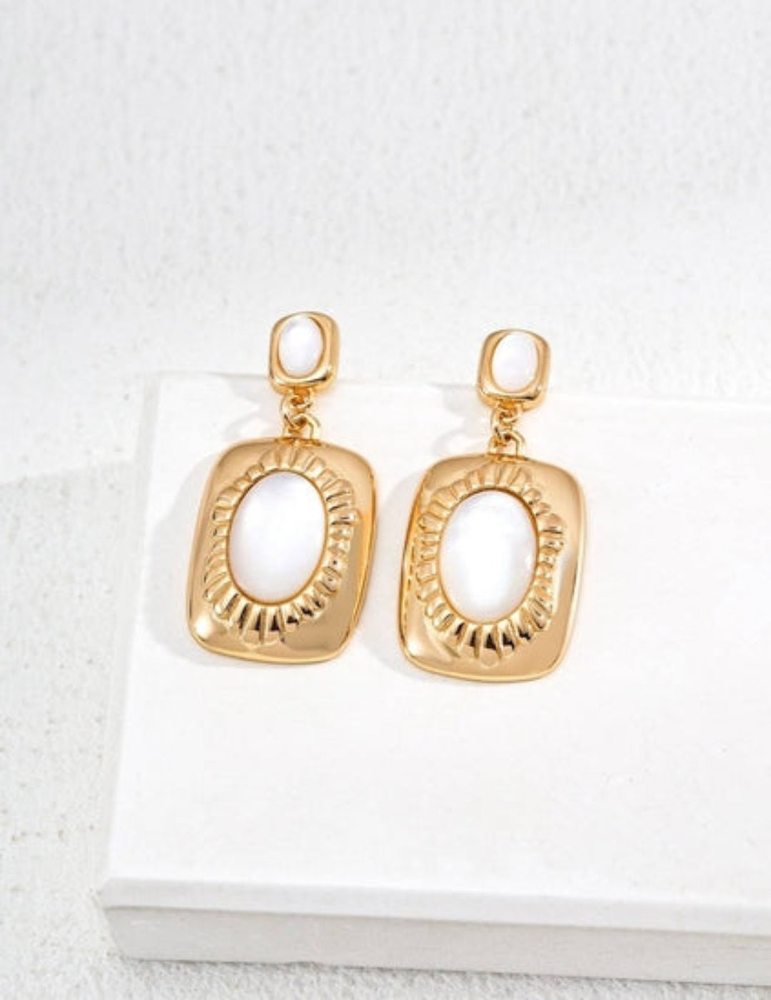 Mother-of-pearl rectangular earrings on display