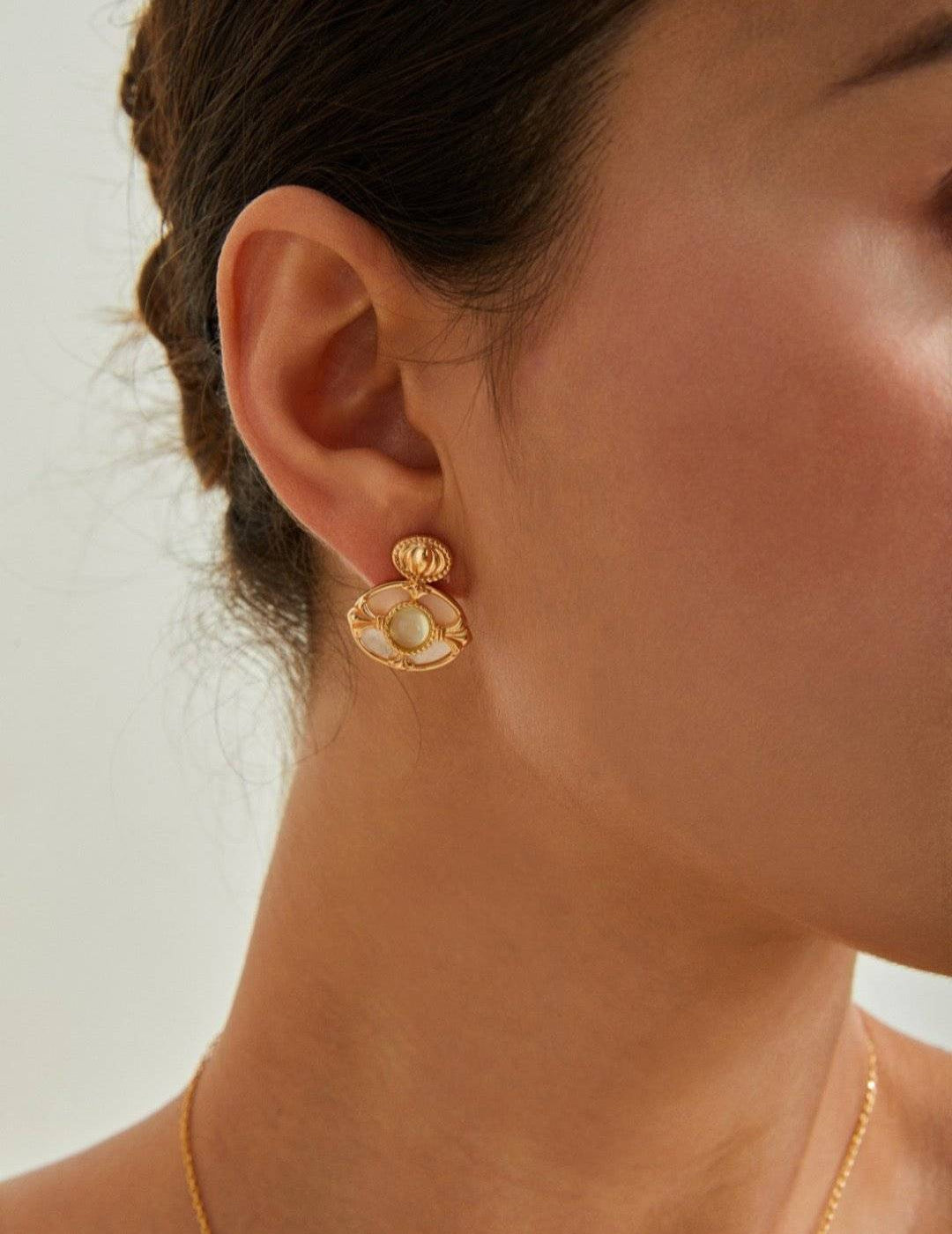 Model wearing gold mother-of-pearl earrings