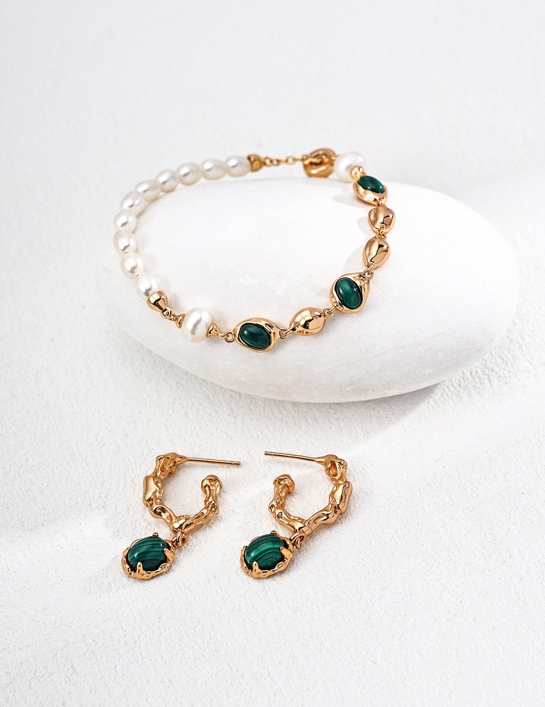 Gold-tone malachite and pearl bracelet displayed with matching malachite drop earrings