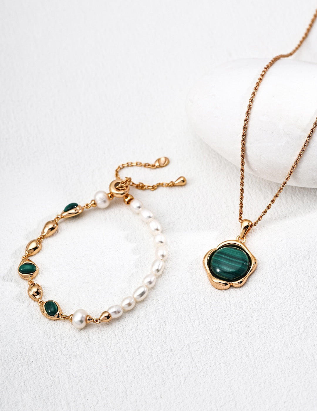 Gold-tone malachite and pearl bracelet displayed beside a malachite pendant necklace