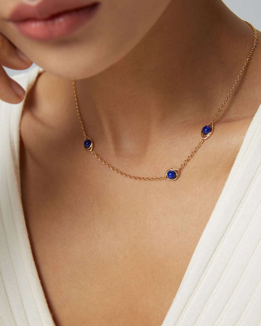 Woman wearing a delicate blue gemstone necklace at collarbone length