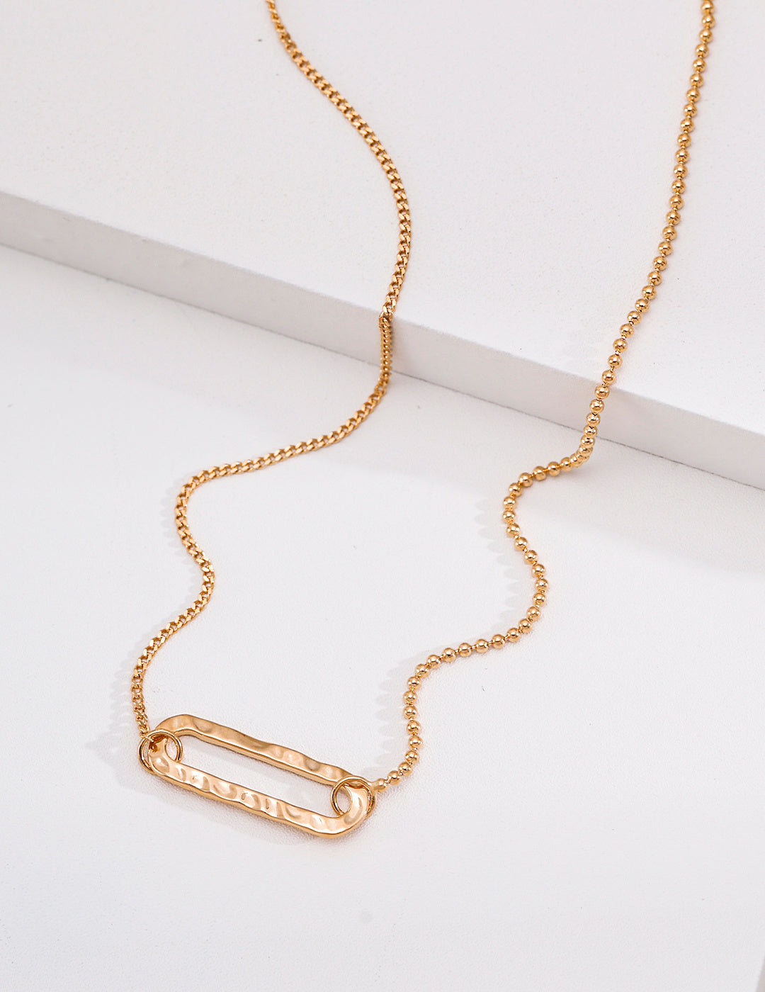 Vintage gold textured rectangle pendant necklace with an asymmetric ball and curb chain