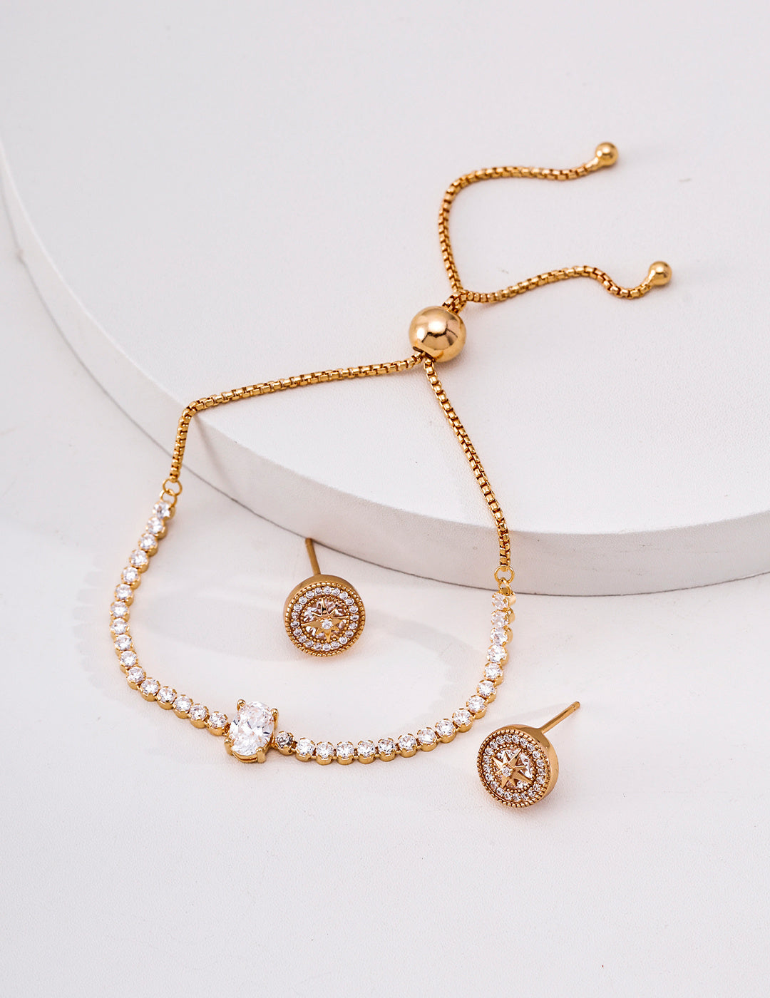 Vintage gold cubic zirconia tennis bracelet displayed with matching gold-tone halo stud earrings