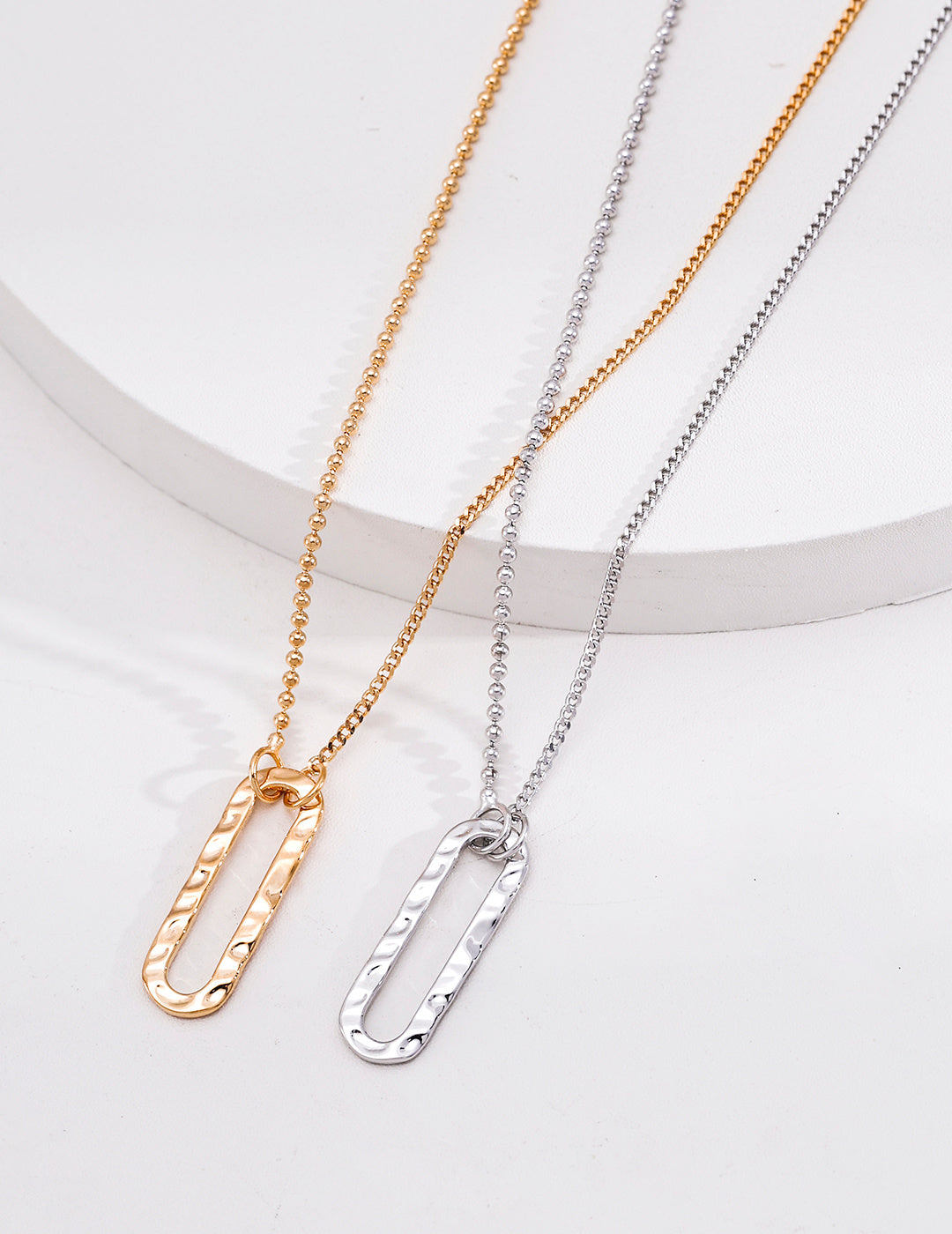 Vintage gold and silver rectangle pendants showing ripple-textured surfaces and contrasting chains