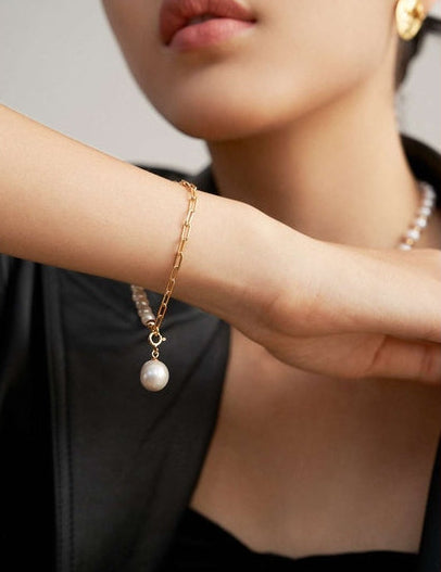Close-up of baroque pearl charm bracelet on model